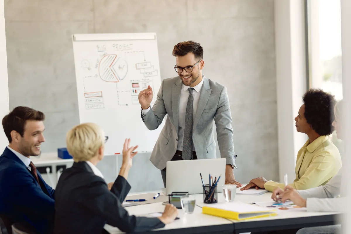 A team leader presenting confidently to colleagues in a meeting room