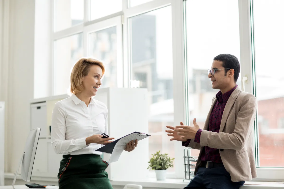 Two colleagues having a respectful, friendly conversation in the office
